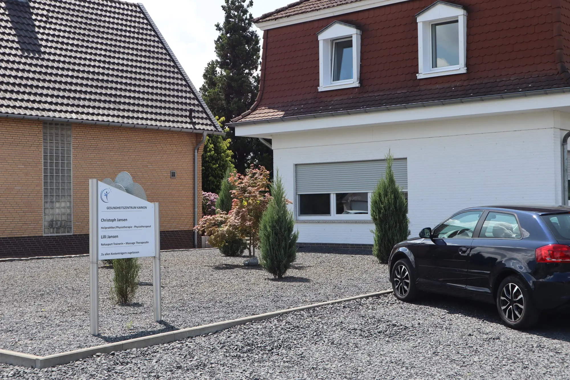 Außenansicht des Gesundheitszentrums Karken mit Praxisschild